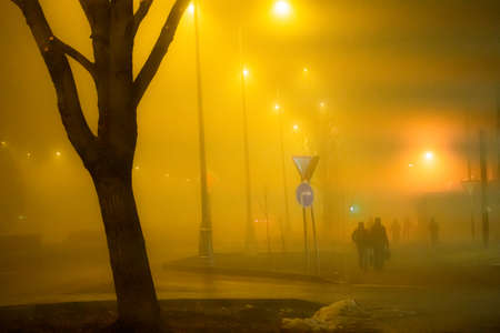 People walk down the street into fogの写真素材