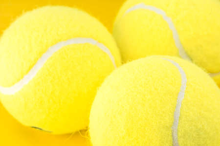 Tennis balls on yellow backgroundの写真素材