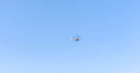 The helicopter flies across the skyの写真素材