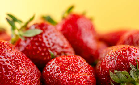 Ripe strawberries on yellow backgroundの写真素材