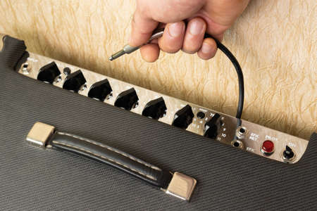 Connecting a cable with a jack connector to a combo amplifierの写真素材