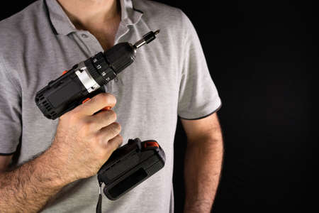 Cordless drill screwdriver in the hands of a manの写真素材