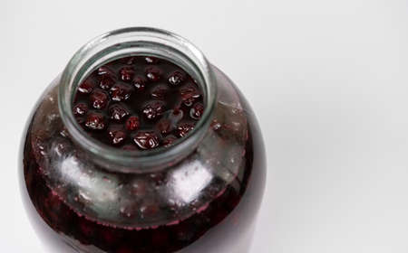 Cherry jam in a jar on a white backgroundの写真素材