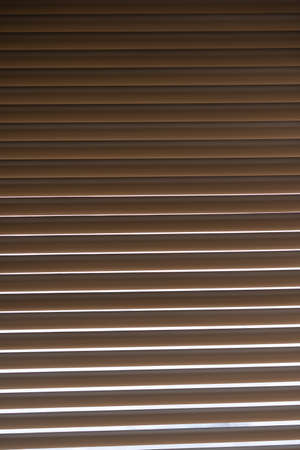 Blinds. The light outside the window shines through the blindsの写真素材