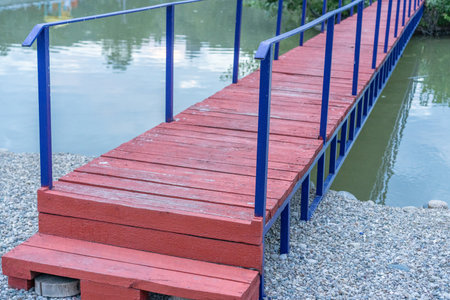 A small wooden bridge over a pondの写真素材