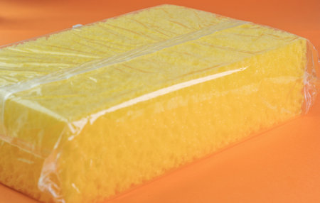 Big yellow sponge on orange backgroundの写真素材