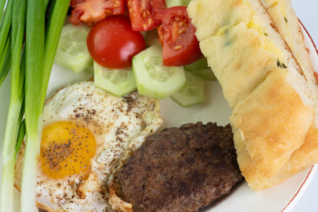 Fried eggs with cutlet and saladの写真素材