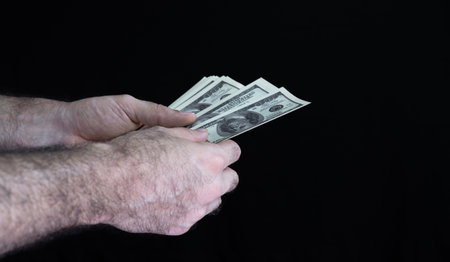Man counts money on black backgroundの写真素材