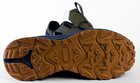 The bottom of a sturdy hiking shoe reveals a detailed tread pattern designed for optimal grip on various surfaces, ideal for outdoor adventures. The shoe blends functionality with rugged style.の写真素材