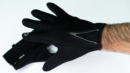 High-tech gloves feature a sleek design with zippers and are suited for outdoor activities in cold conditions. Ideal for maintaining warmth while using touch screens efficiently.の写真素材