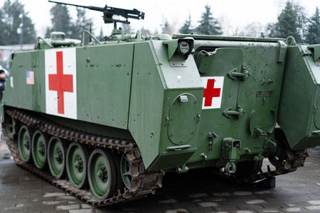 A military medical vehicle stands ready for action, showing its distinct red crosses. The surroundings feature dense trees, indicating a potential operational or training setting.の写真素材