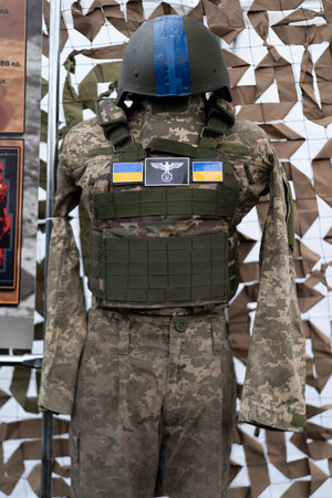 A tactical military uniform stands displayed in a showcase, showcasing camouflage pattern and protective gear.の写真素材