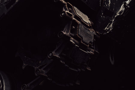 A detailed shot captures an aged mechanical part, highlighting its rust and deterioration in a low-light environment that evokes an industrial feel.の写真素材