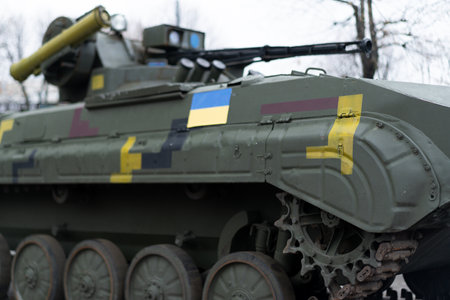 A military vehicle is parked in an urban setting, highlighting its unique camouflage patterns and various operational features. It demonstrates modern military design and tactical capabilities.の写真素材