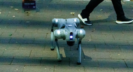 A sleek robot dog moves through a vibrant urban park, approaching a passerby. Sunlight filters through trees, highlighting paths and autumn leaves around.の写真素材