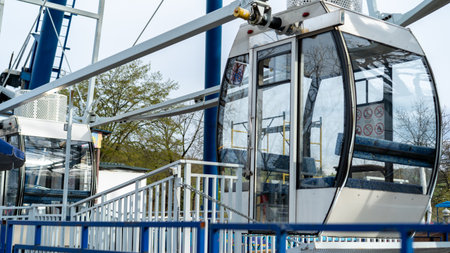 Two gondolas wait at the station, their doors open as visitors prepare to board. The atmosphere is...