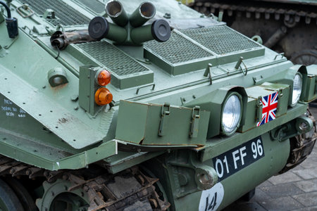 A historic armored vehicle is prominently displayed in a city center during a military event. Visitors explore the vehicle, appreciating its design and historical significance.の写真素材