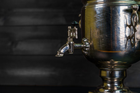 A close-up of a traditional metal samovar featuring a detailed spout, showing its vintage...