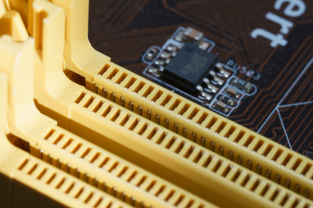 Detailed view of a circuit board featuring yellow connectors and a small black chip. This setting captures an intricate aspect of electronic components and design.の写真素材