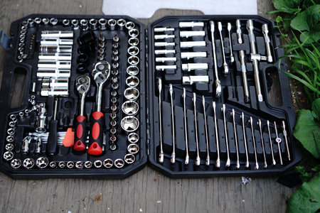 A black toolbox displays a complete set of tools, including sockets, ratchets, and bits, laid out...