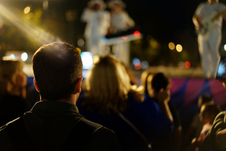 People gather at a lively outdoor music event during the night, enjoying performances by musicians. The atmosphere is energetic, filled with excitement and joy as attendees engage with the show.の写真素材
