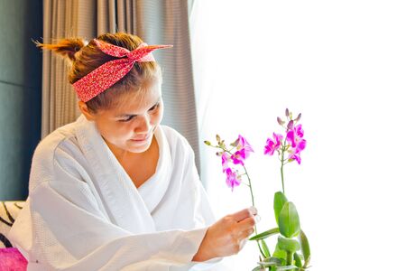 Lady wearing nightgown and flower arrangement in the morningの写真素材