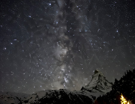 A captivating view of a starry night sky featuring the Milky Way above a majestic mountain landscape. Perfect for nature and travel enthusiasts seeking serene beauty.の素材
