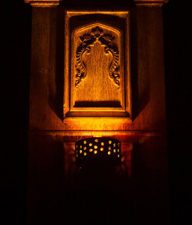 Old wall lamp against wooden wallの写真素材