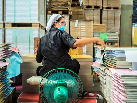 Asian women grouping a paper pile to ready to make a book in book factoryの写真素材