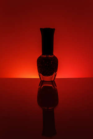 Nail polish bottle on red backgroundの写真素材