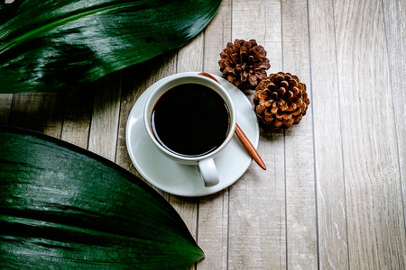 Coffee cup on wooden table in garden