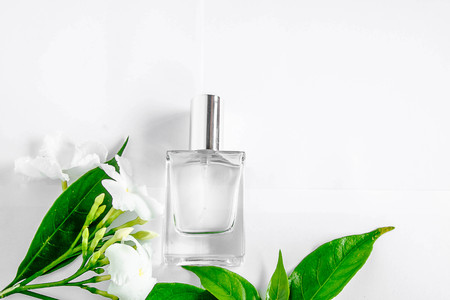 Perfume bottle and white flower with green leaf on white background.の写真素材