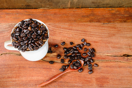 Coffee cup and coffee beans on wooden table
