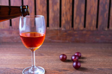 Pour red wine into a glass of wineの写真素材