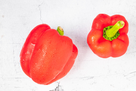 Red and yellow bell peppers on wooden background.の写真素材