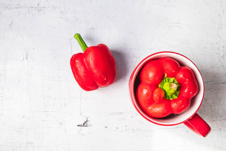 Red and yellow bell peppers on wooden background.