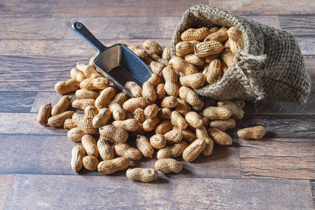 Peanut in sackcloth on wood background