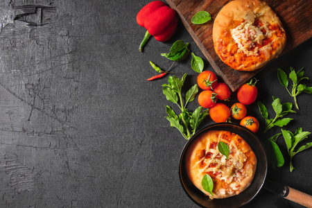 Pizza in a pan with pizza on a wooden tray
