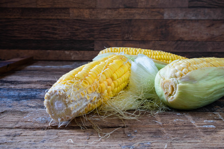 Fresh maize on wooden floor