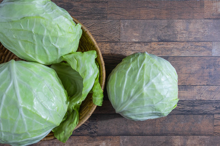 Cabbage in a basket on a wooden tableの写真素材