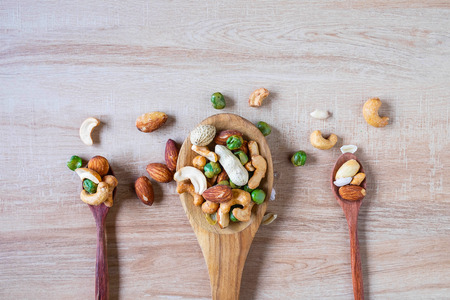 Mixed nuts on a wooden spoon