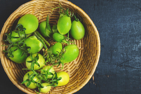 Fresh green tomatoes in a basketの写真素材