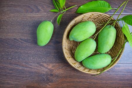 Fresh green mango fruit in a wooden basketの写真素材