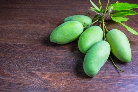 Fresh green mango fruit on a wooden tableの写真素材