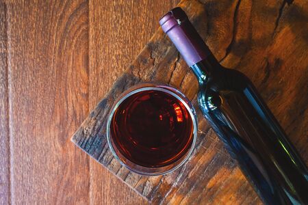 Wine glass and wine bottle on the wooden tableの写真素材