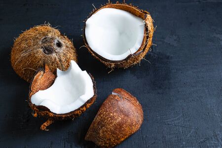 Coconut cut in half on a black backgroundの写真素材
