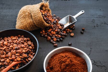 Coffee beans and coffee powder on a black wooden backgroundの写真素材