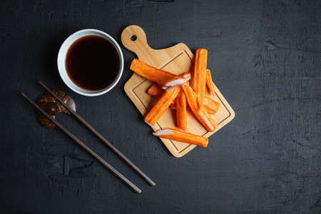 Crab sticks and Japanese sauce on a black backgroundの写真素材
