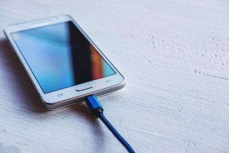 Charge the mobile phone on the table.の写真素材
