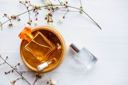 Perfume bottle with flowers on a white wooden backgroundの写真素材